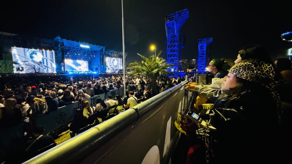 Fotografía de la vista al escenario Banco de Chile de noche, desde la tarima accesible correspondiente, en la esquina derecha de la tarima está la palmera que obstruye la vista.